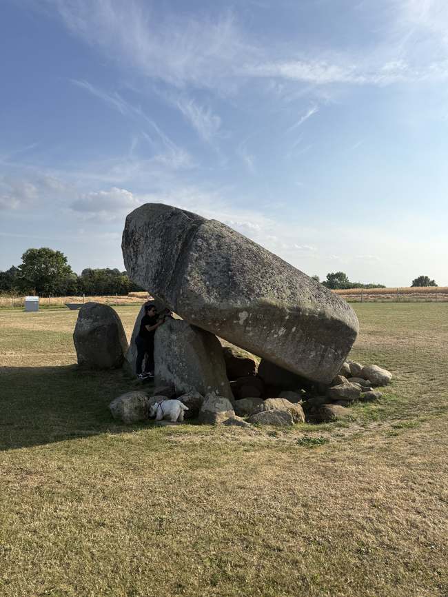 Una persona junto a la losa del Dolmen de Brownshill, mostrando la escala real de la piedra