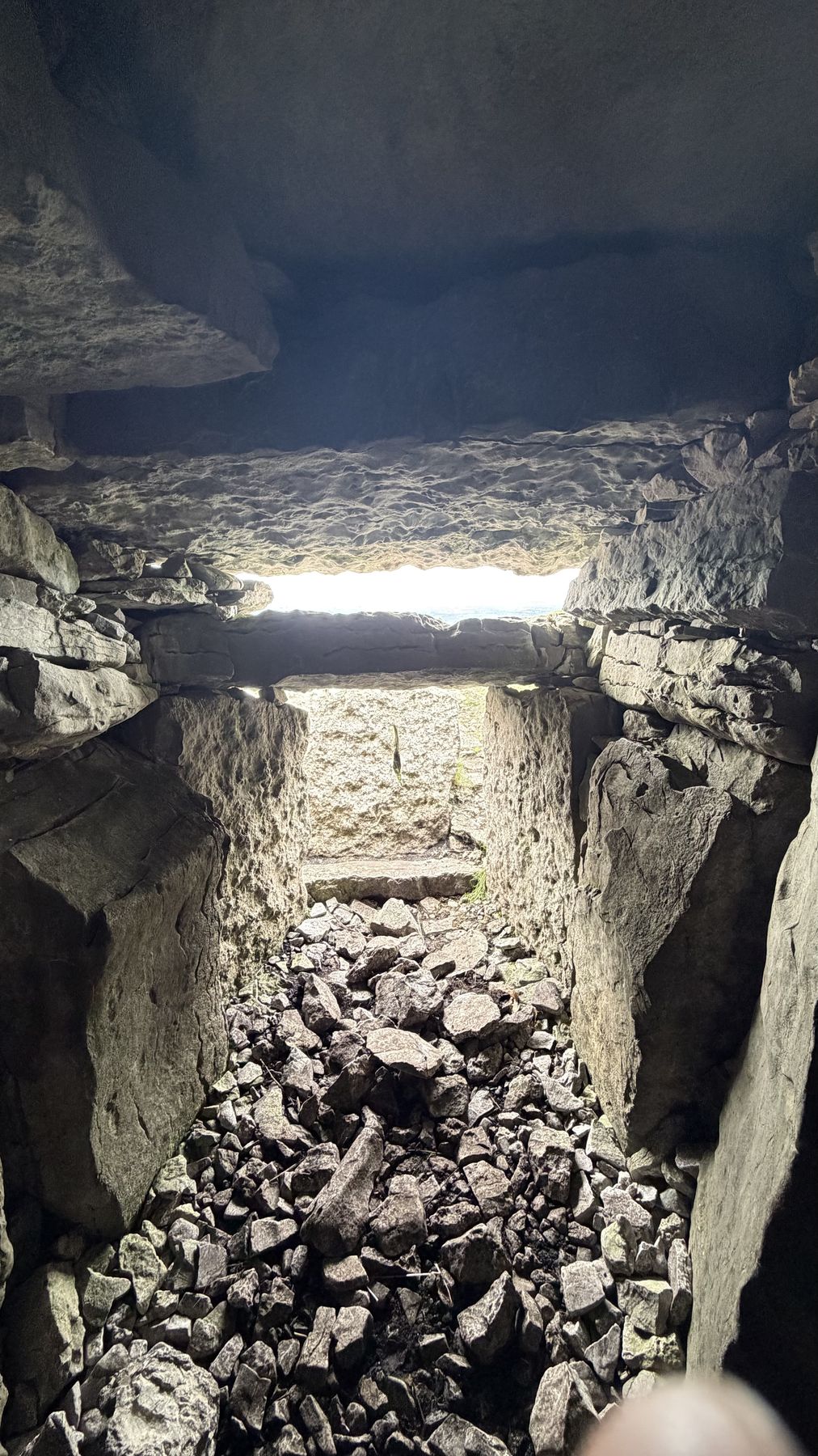 Luz entrando por la abertura del pasadizo de un cairn de Carrowkeel