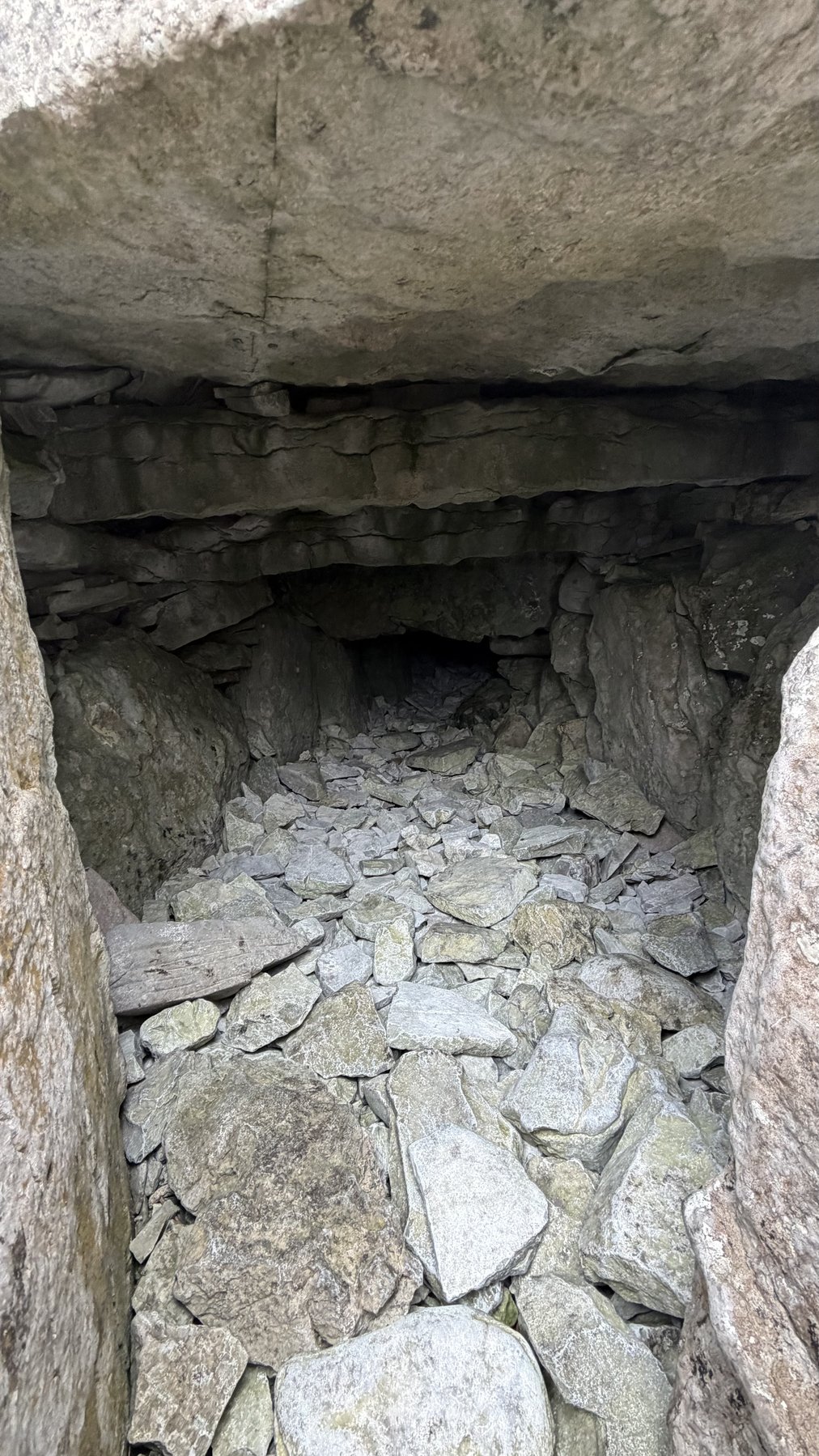 Túnel de piedra en penumbra dentro de un cairn de Carrowkeel