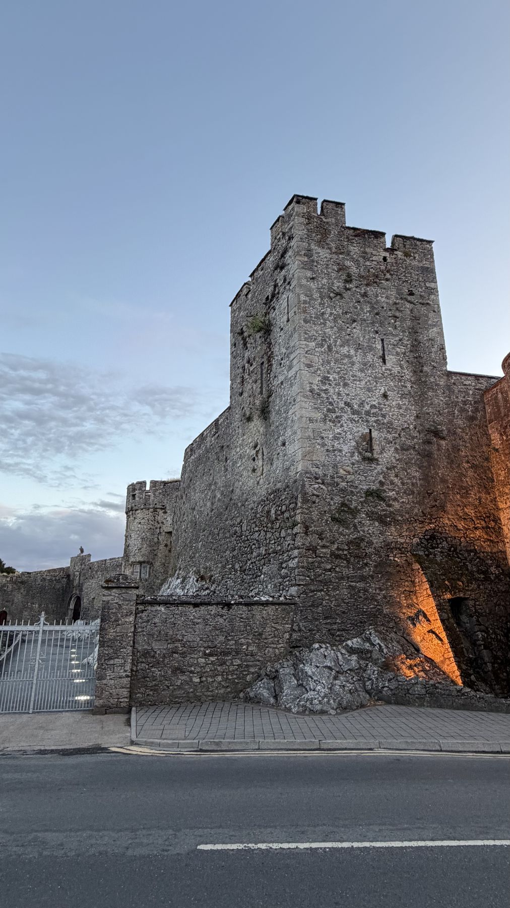 Muralla y torre del Castillo de Cahir iluminadas al anochecer