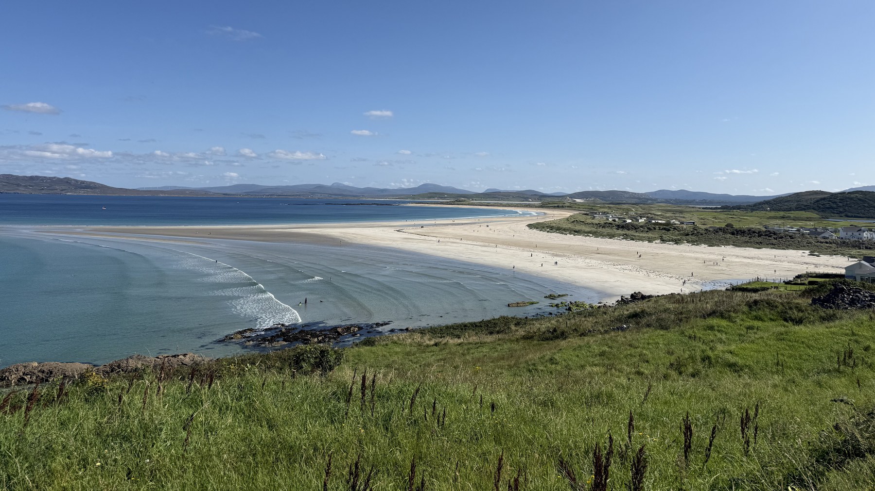 Amplia playa de arena del condado de Donegal, con montañas al fondo