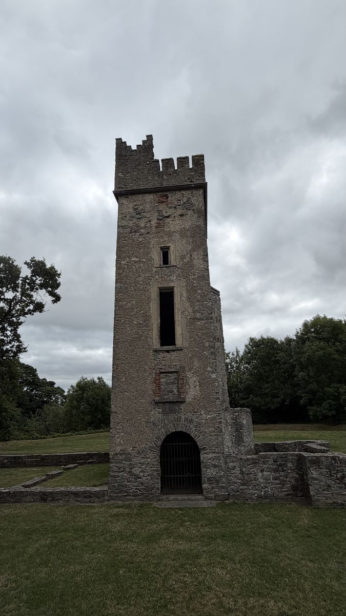La torre en ruinas de Dún Dealgan vista de frente, con la muralla circular de la base a su alrededor