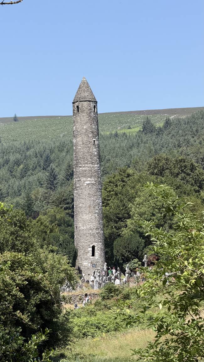 Torre redonda de Glendalough entre el bosque