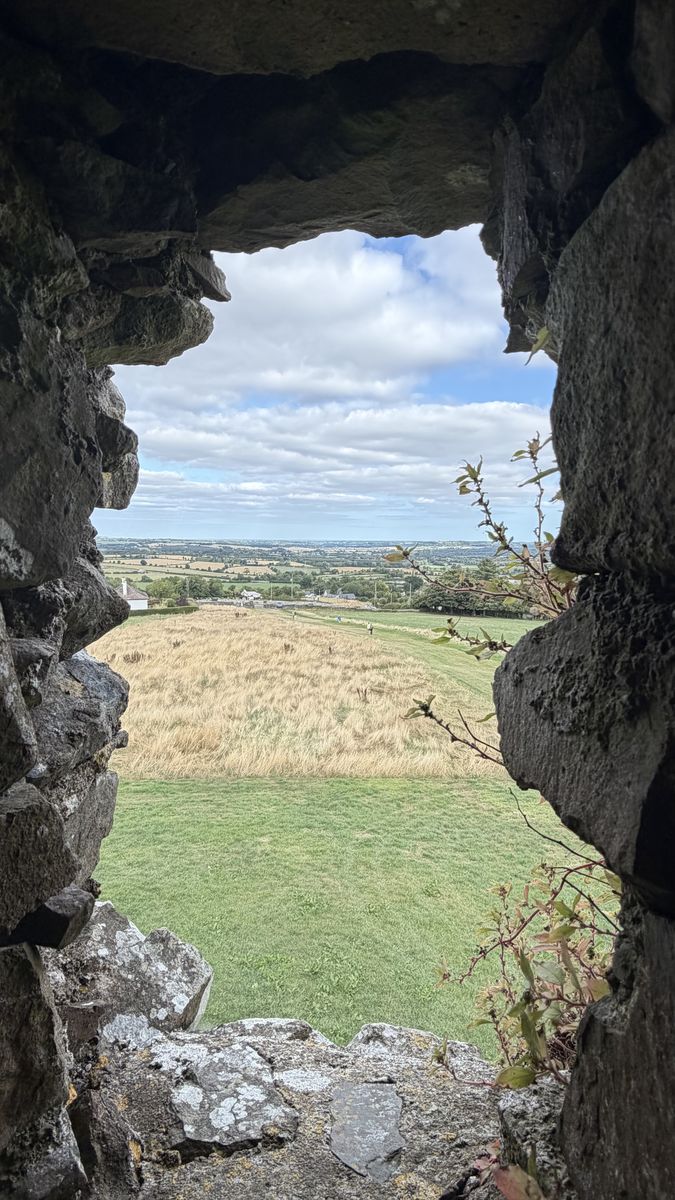 El campo de Meath visto a través de una ventana en ruinas de la Colina de Slane