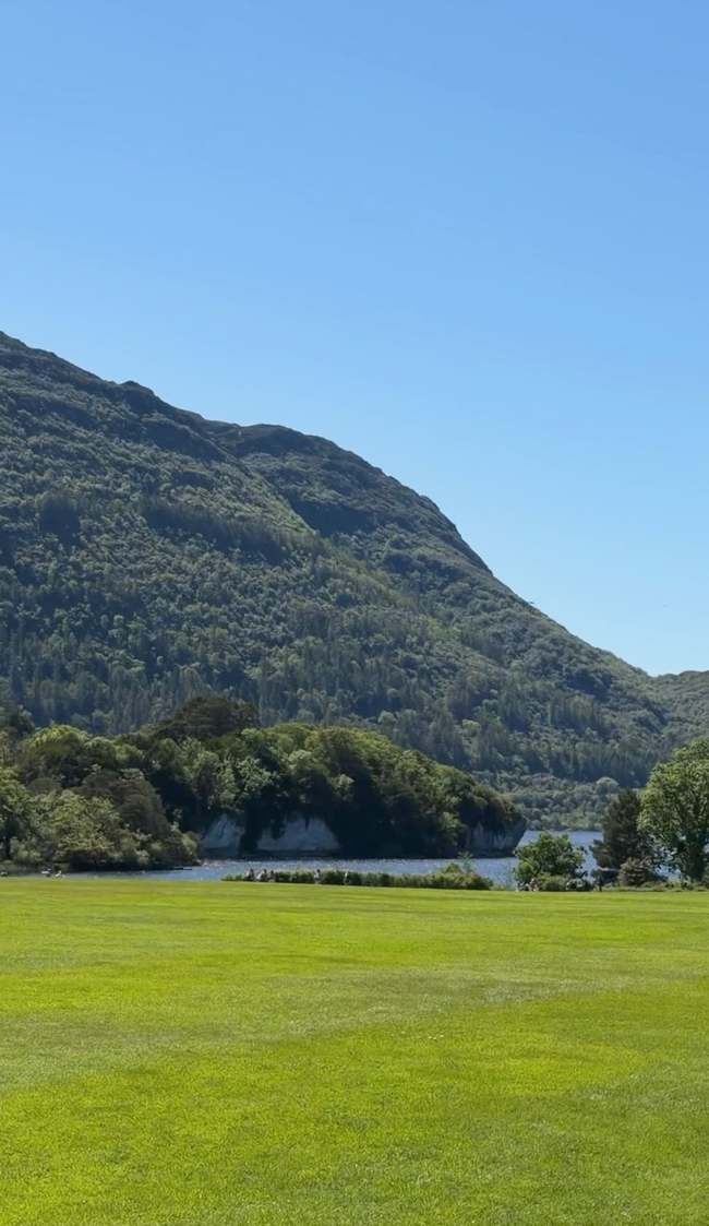 Vista del lago y las montañas desde los jardines del parque