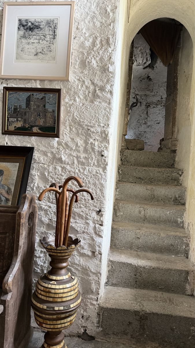 Otra escalera de piedra del castillo, junto a pinturas enmarcadas colgadas en la pared