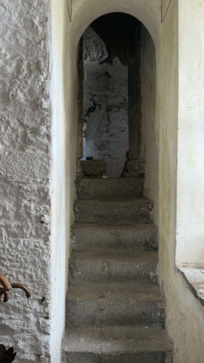 Una estrecha escalera de piedra dentro de una de las torres del castillo