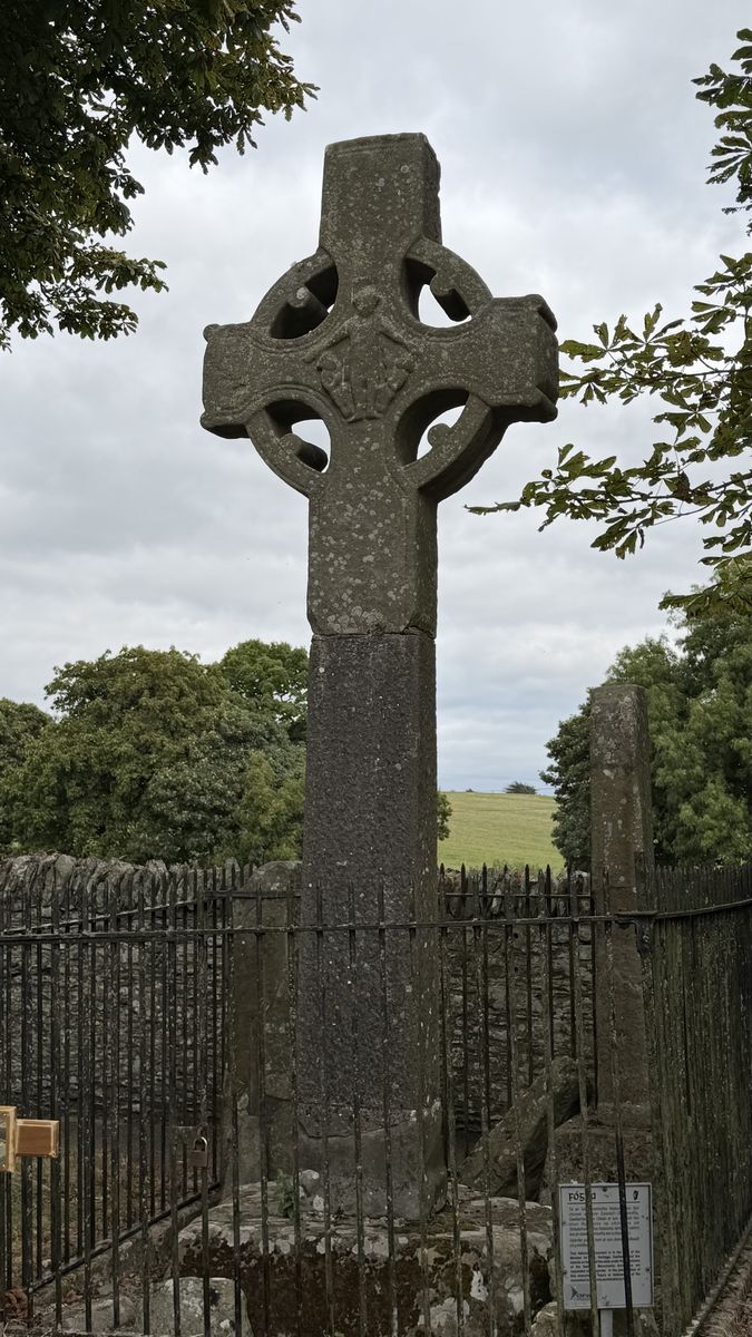 La Cruz Norte de Monasterboice, más sencilla y con menos decoración, rodeada de una verja
