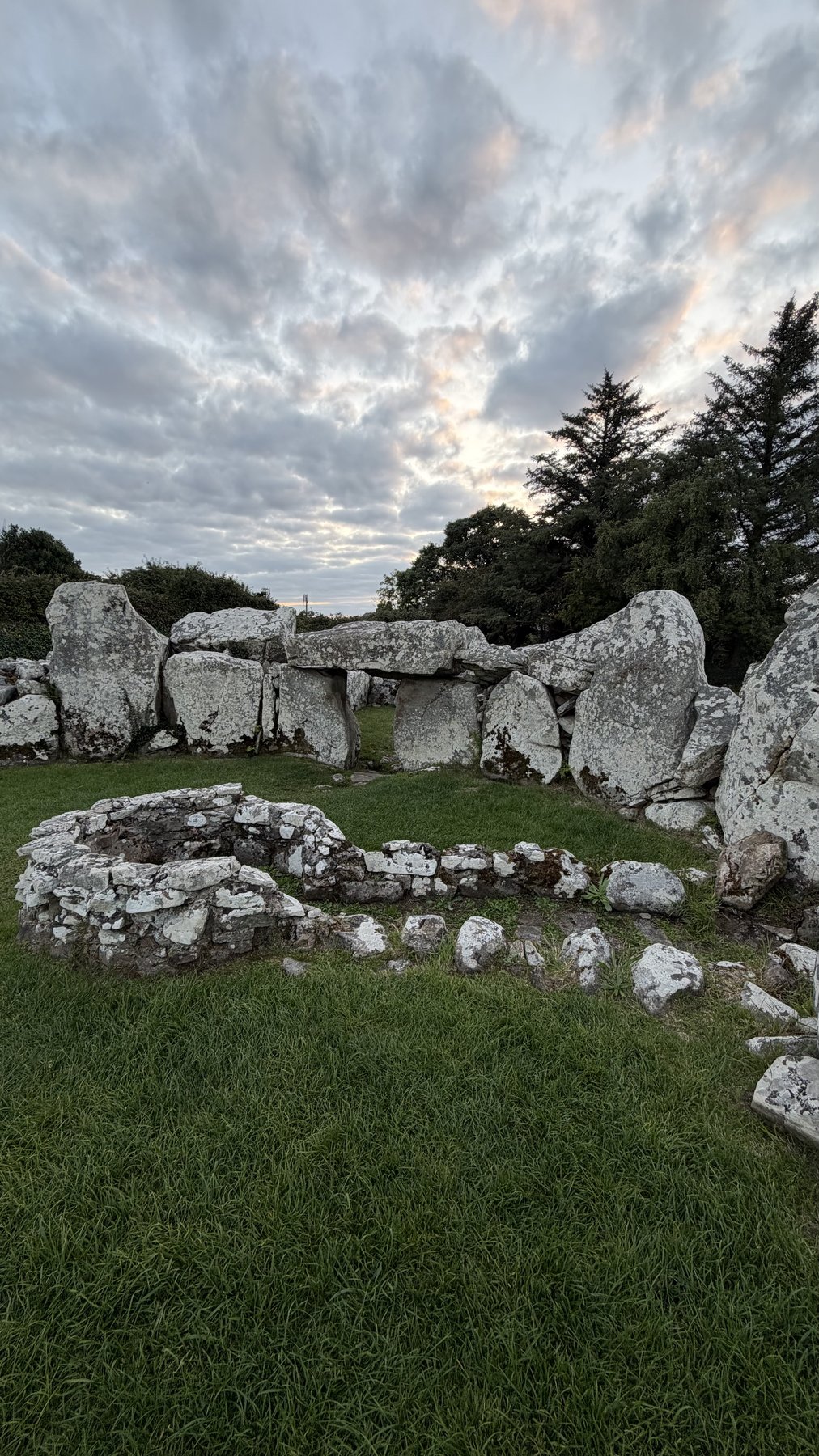 Vista amplia de la Tumba de Creevykeel mostrando las dos cámaras y el cerco de piedra bajo